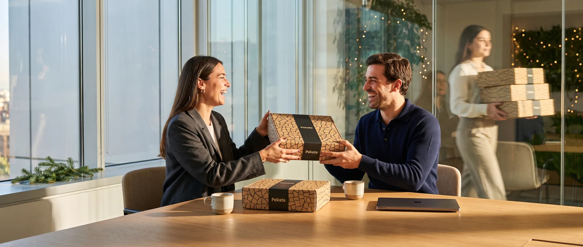 Entrega de una caja de regalo Pekata entre dos profesionales en una sala de reuniones